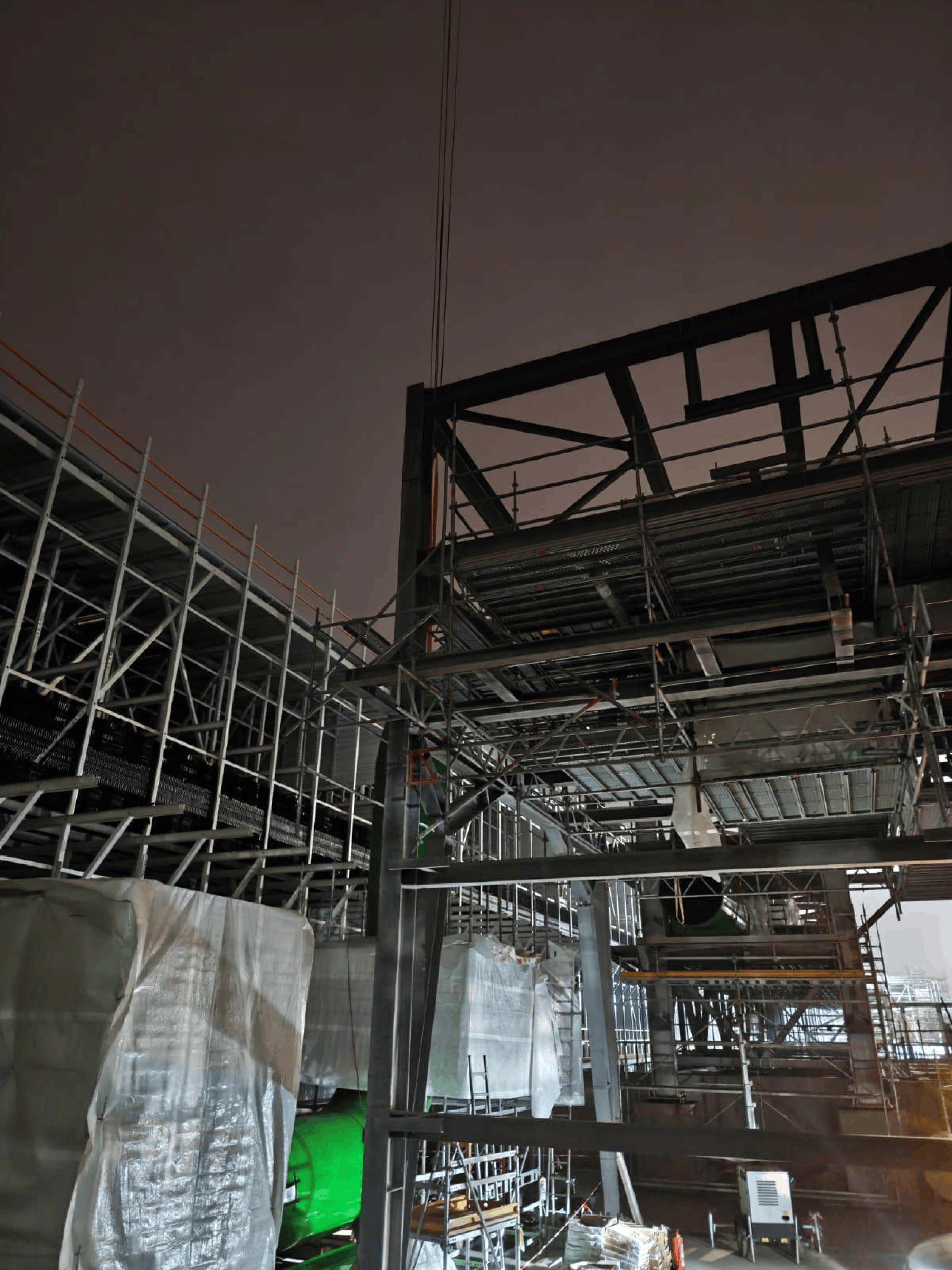 Steel structure under construction illuminated at night