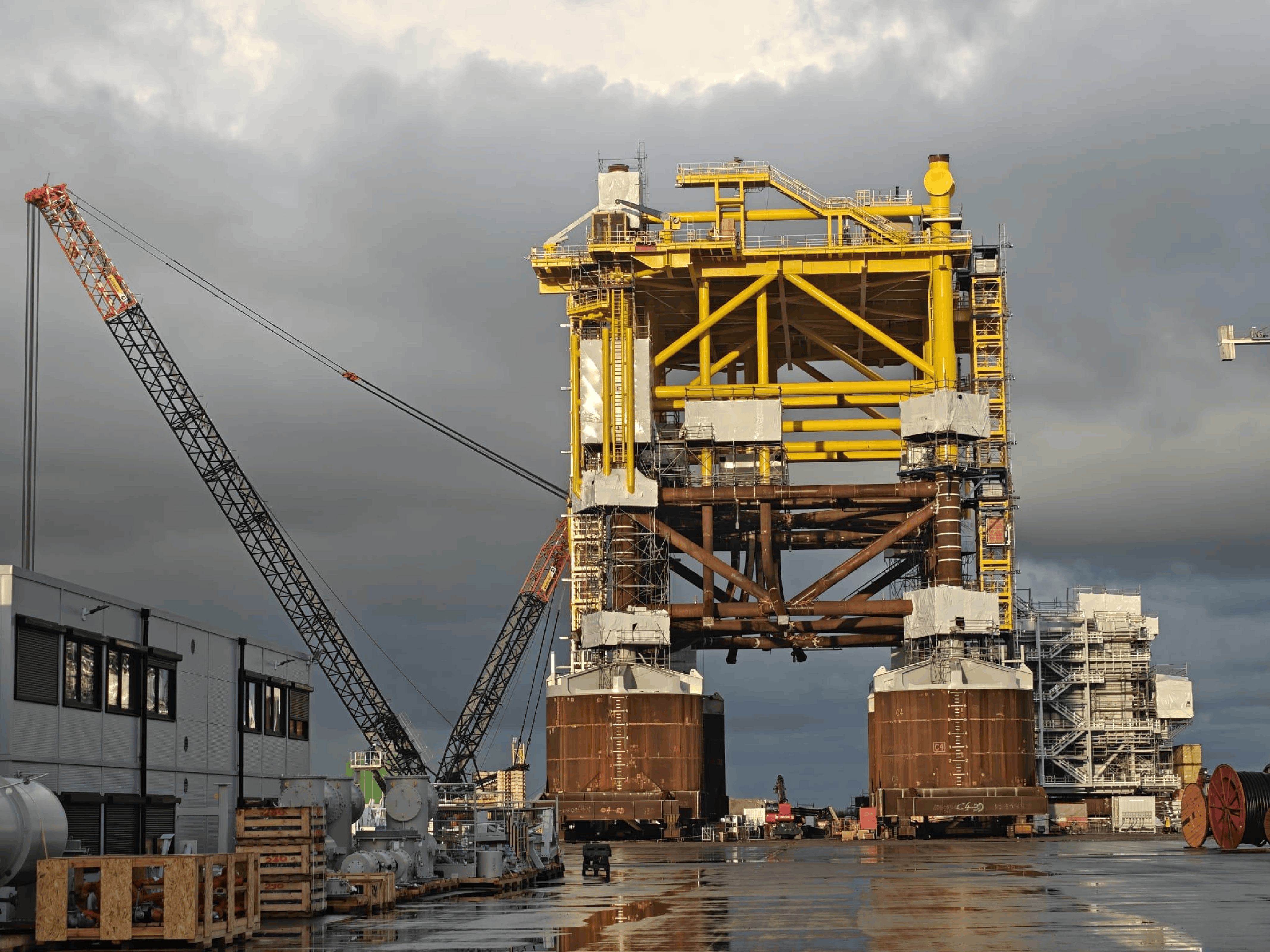 Large offshore platform substructure assembled at port facility with crane
